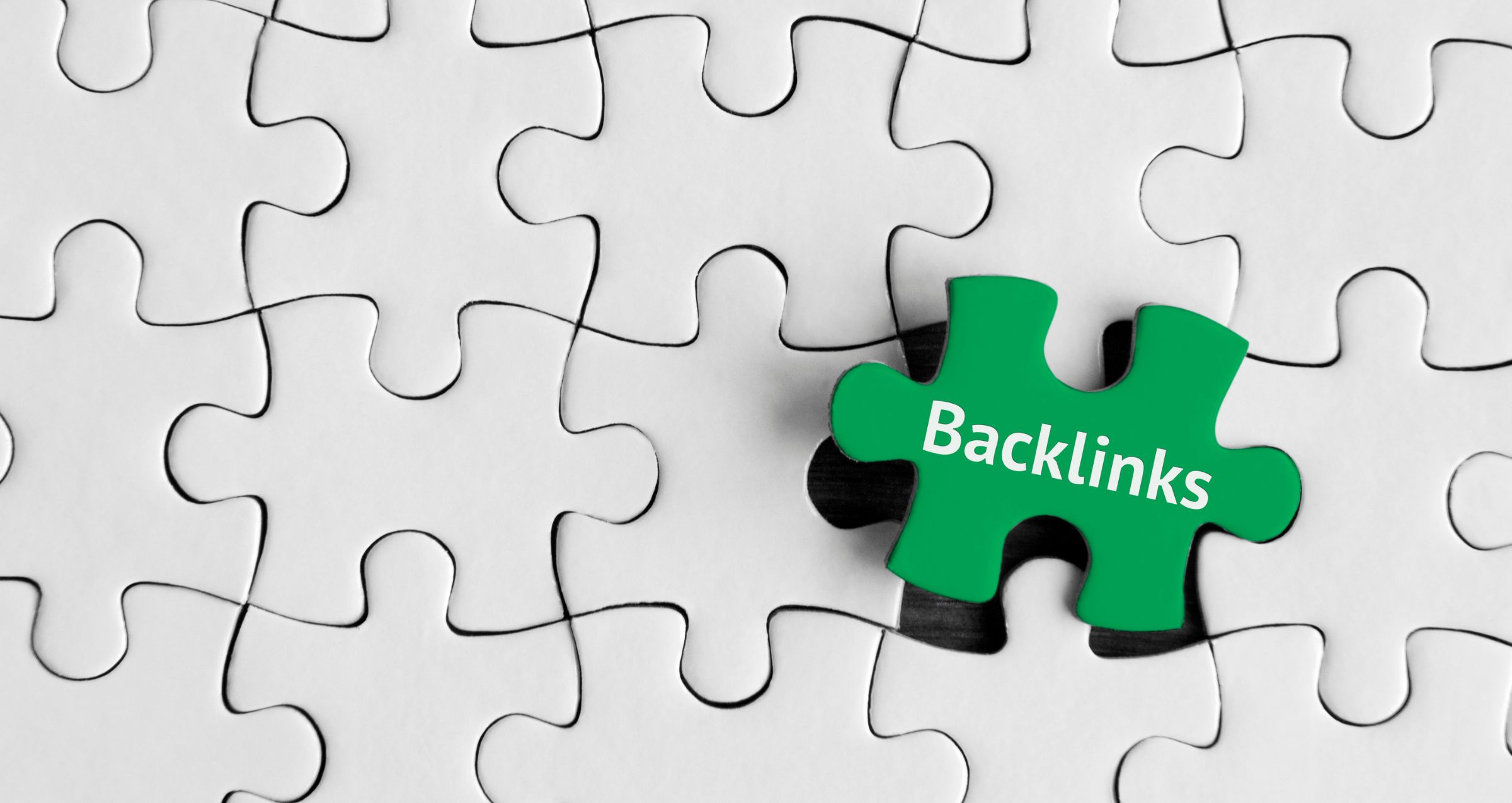 White puzzle with a green puzzle piece that reads 'backlink' - blogpost is about spammy backlinks